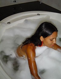 A naked Latina chick in bed and in the bathtub