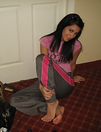 Her shiny workout pants are tight against her ass and Raven Riley wears a pink tee with them.